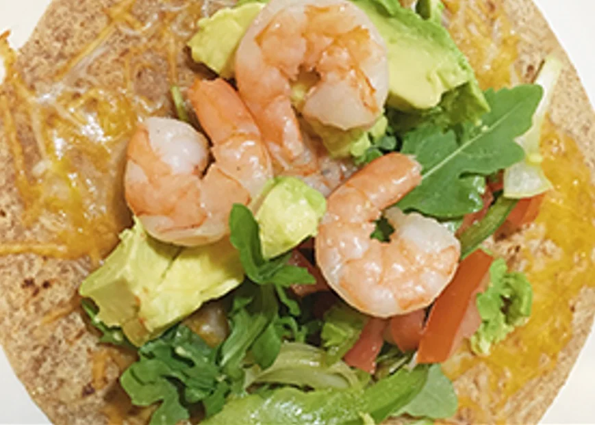 Shrimp Quesadilla - A golden, crispy flour tortilla stuffed with seasoned shrimp, melted cheese, peppers, and onions. Served with sour cream, guacamole, and fresh pico de gallo.